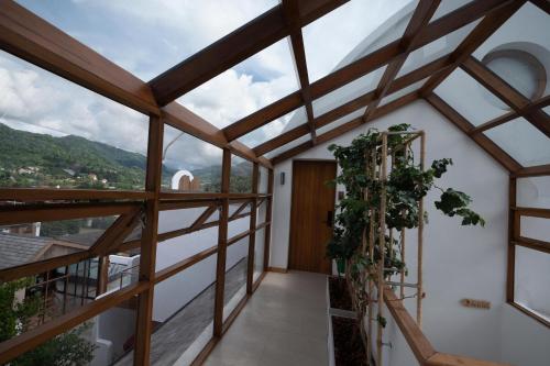 a room with a balcony with windows and plants at 108 Villa @ PongYang in Chiang Mai
