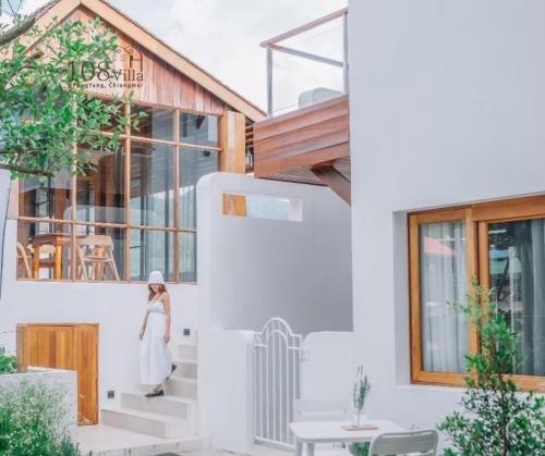 a woman walking down the stairs of a white house at 108 Villa @ PongYang in Chiang Mai
