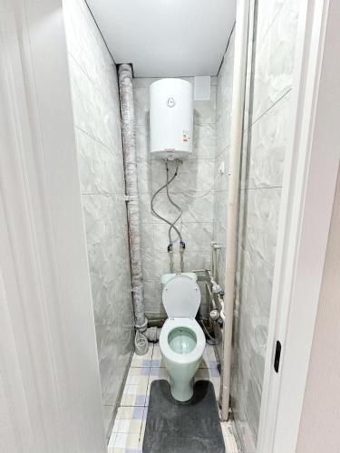 a bathroom with a toilet in a small room at Kabay 7 in Semey
