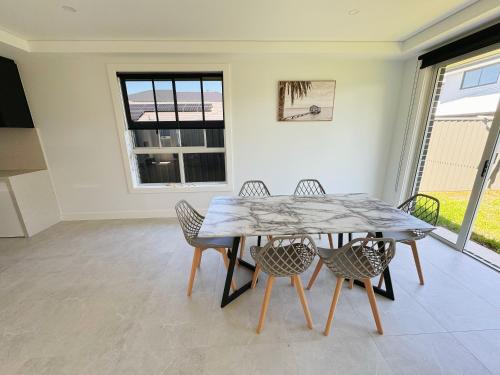 a dining room with a table and chairs at Luxury Newly Built Home Queen Room in Marsden Park