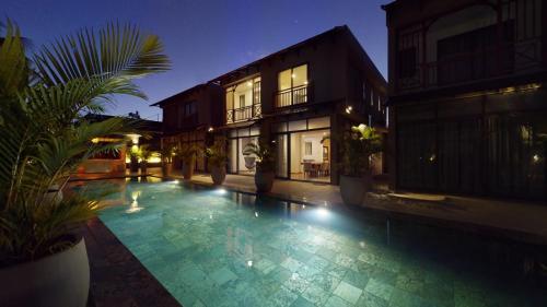 a swimming pool in front of a building at night at Paradise in the Heart of Mauritius in Grand Baie