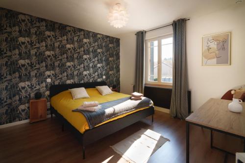 a bedroom with a bed with yellow sheets and a wallpaper at " La belle vie ", Demeure de charme en Champagne in Dormans