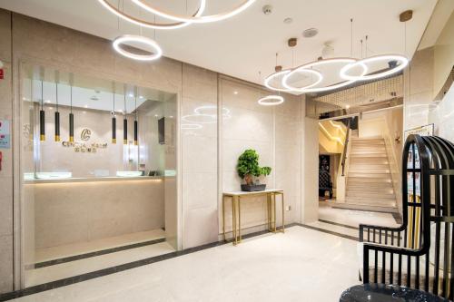 a lobby with a staircase and a potted plant at Center Hotel Xi'an Bell Tower in Xi'an