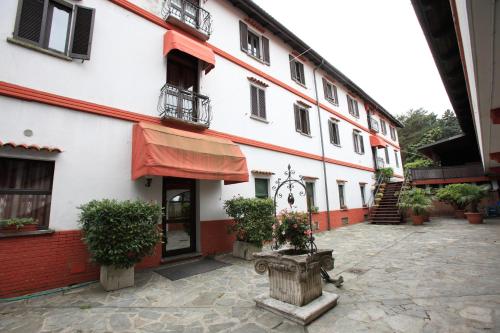 a white building with a red awning and a courtyard at Il Castello B&B in Varallo Pombia