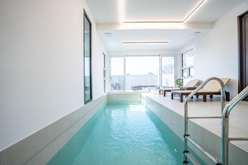 una piscina con acqua blu in un edificio di Peer Haus Private House a Gangneung