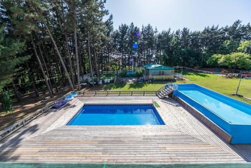 a large swimming pool in a yard next to a field at Taean Red Balloon Pension in Tangam-ni