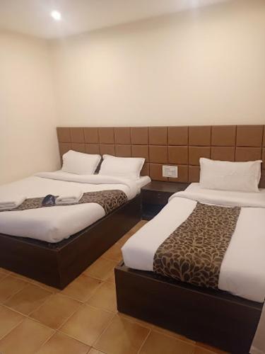 a hotel room with two beds in a room at Grandkodai in Kodaikānāl