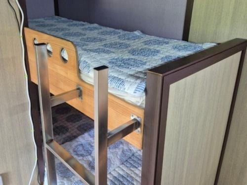 - un petit lit dans une chambre avec deux portes dans l'établissement Cheongdo Provence Light Festival Caravan Pension, à Cheongdo