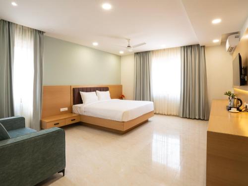 a hotel room with a bed and a couch at Hotel Orchid Suites Kokapet, Business Hotel in Hyderabad