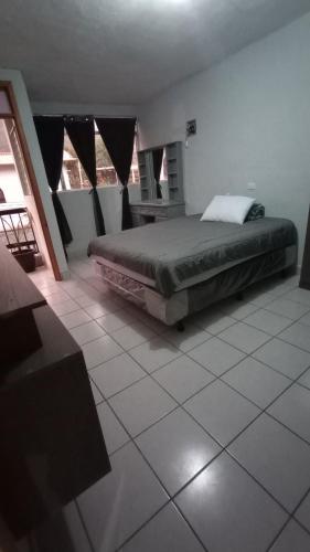 a bedroom with a large bed and a table at CENTRAL APARTMENT, casa cuc in Panajachel