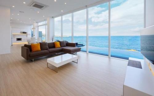 a living room with a couch and a view of the ocean at Pohang Escape Ocean View Pool Villa in Hajŏng-ni