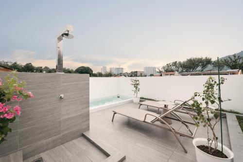 a balcony with a bench and a swimming pool at Romantic Rooftop Jacuzzi Villa with Sunset Views in Jelutong