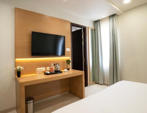 a hotel room with a television on a wall at Hotel Orchid Suites Kokapet, Business Hotel in Hyderabad