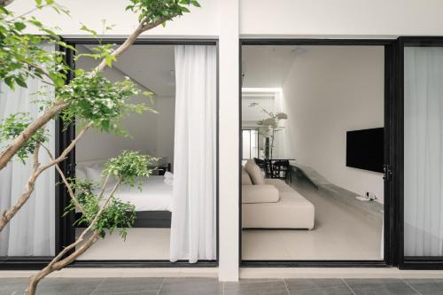 a bedroom and a living room with sliding glass doors at Romantic Rooftop Jacuzzi Villa with Sunset Views in Jelutong