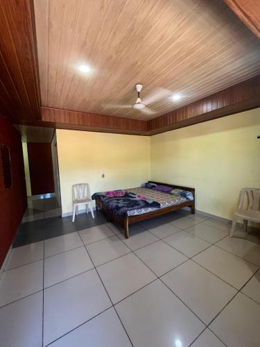a bedroom with a bed and two chairs in it at Avani Residence in Sringeri