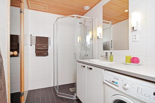 uma casa de banho com um chuveiro e uma máquina de lavar roupa em Forenom Serviced Apartments Tampere Pyynikki em Tampere