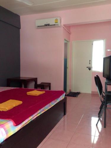 een slaapkamer met een bed met een rood dekbed bij Rossarin Seeview 2 in Noord Pattaya