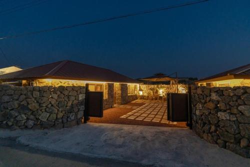 a stone wall in front of a house at night at Stay Onwol in Kwidŏng-ni