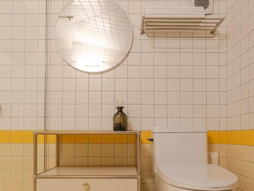 a bathroom with a toilet and a light on the wall at Stay Onwol in Kwidŏng-ni