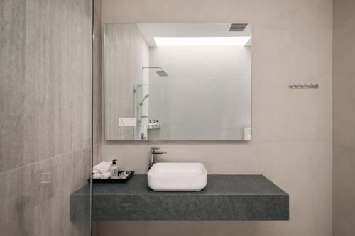 a bathroom with a sink and a mirror at Romantic Rooftop Jacuzzi Villa with Sunset Views in Jelutong