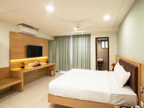 a hotel room with a bed and a television at Hotel Orchid Suites Kokapet, Business Hotel in Hyderabad