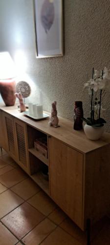 un comptoir en bois avec un vase et des fleurs dessus dans l'établissement Gite le nid du canal, à La Celle-sous-Gouzon