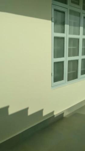 a window on the side of a white building at Nidaya Guest house in Cherrapunji