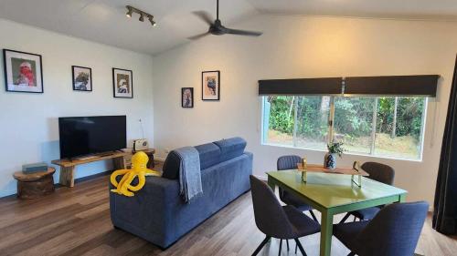 a living room with a blue couch and a table at The Sugar Shack - Relax and unwind in Miallo