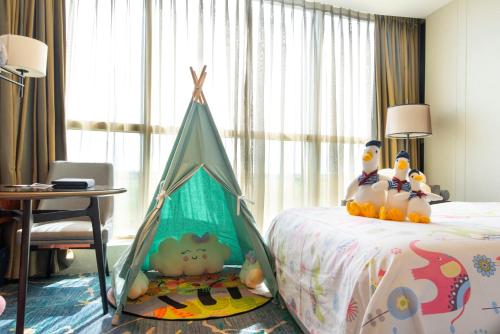 a bedroom with a bed with a tent on it at Sheraton Shanghai Chongming Hotel in Chongming