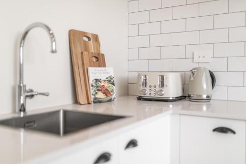 a kitchen counter top with a sink and a sink at 3 Bed Family Retreat Classic Charm With Park Views in Christchurch