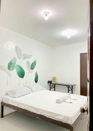 a bedroom with a bed with leaves painted on the wall at Inn Convenience in Coron