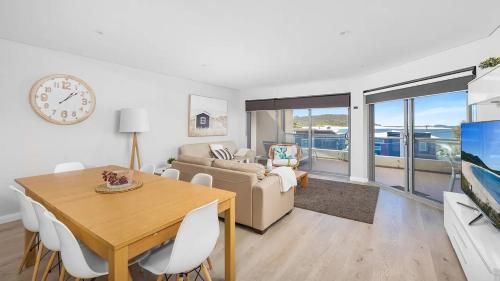 a living room with a table and a couch at Solaris in Fingal Bay