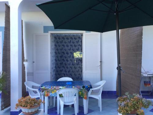 a table and chairs with an umbrella on a patio at Casa Acqua Marina Ponza in Ponza