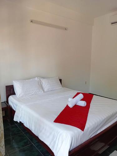 a white bed with a red towel on it at MUINE MOMO Homestay in Ấp Khánh Phước (1)