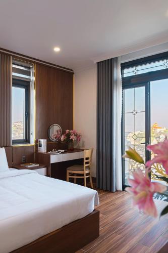 a hotel room with a bed and a desk at Quỳnh Phương Villa Đà Lạt in Ấp Kim Thạch