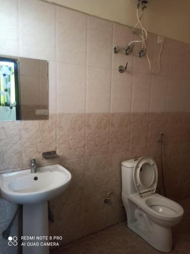 a bathroom with a toilet and a sink at Hotel Food Mania in Ner Chowk