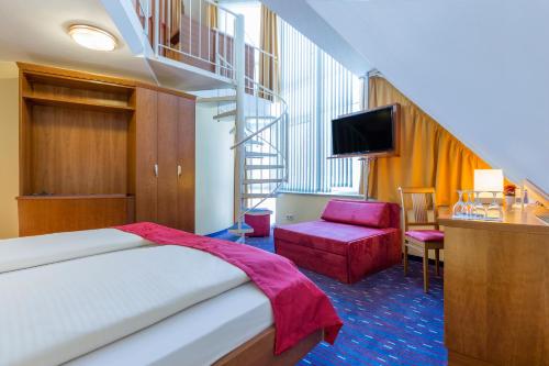 a hotel room with a bed and a staircase at Hotel am Schillerpark in Esslingen