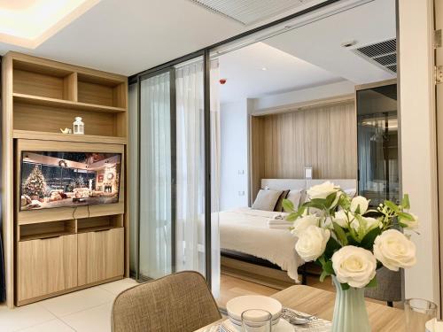 a bedroom with a bed and a table with a vase of flowers at Circle 31 #1BR Bangkok in Bangkok