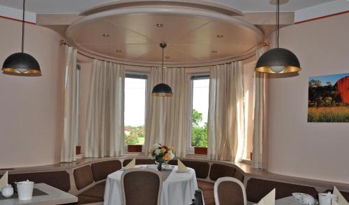 a dining room with a table and chairs and windows at Häuser der Villa Italia in Marktheidenfeld