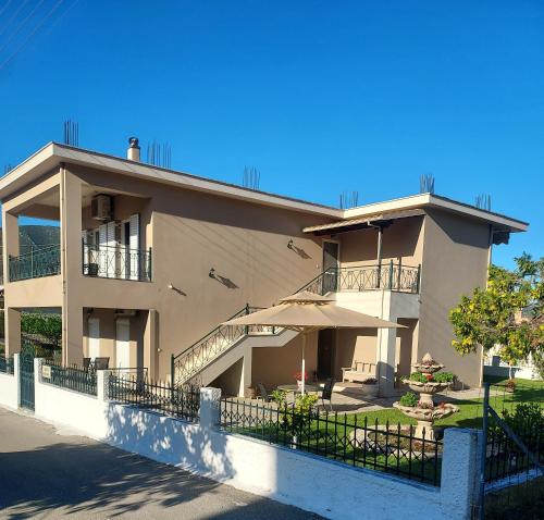 a large building with a patio and an umbrella at ΔΙΑΜΈΡΙΣΜΑ ΜΕΝΤΗΣ in Igoumenitsa