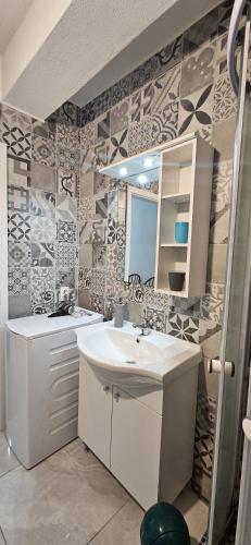 a bathroom with a sink and a mirror at Bella Nina Apartments in Šilo