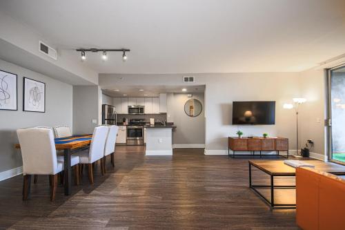 a dining room and living room with a table and chairs at Sunny 2BDR in SM Pool & Gym - 5 min to the beach! in Los Angeles