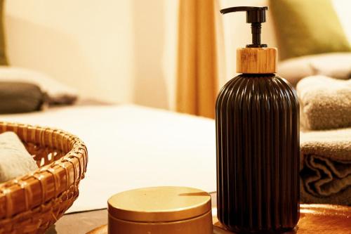 a black bottle on a table next to a basket at Thanicha Resort Amphawa in Amphawa
