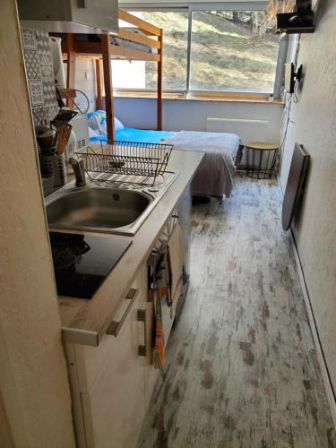- une cuisine avec évier et un lit dans une chambre dans l'établissement Studio à Super Besse, à Besse-et-Saint-Anastaise