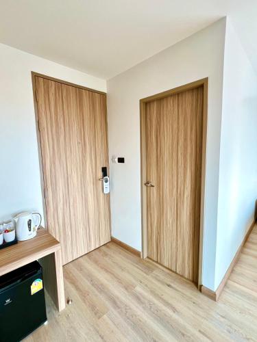 a room with two wooden doors in a room at เวลโกรว์ โฮเทล - Wellgrow Hotel in Ban Bang Kha
