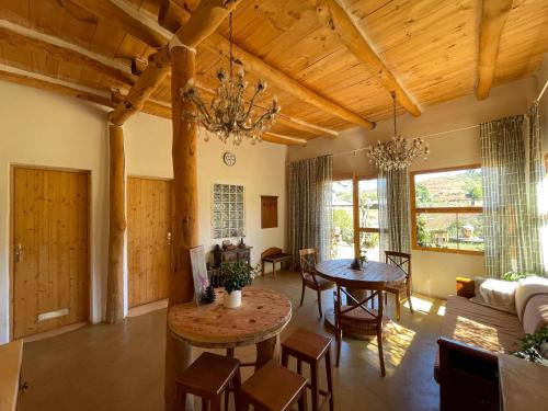 a living room with wooden ceilings and a table and chairs at Nature Sanctuary, a semi-detached house on an ecological & sustainable farm in Santa Maria de Guia de Gran Canaria