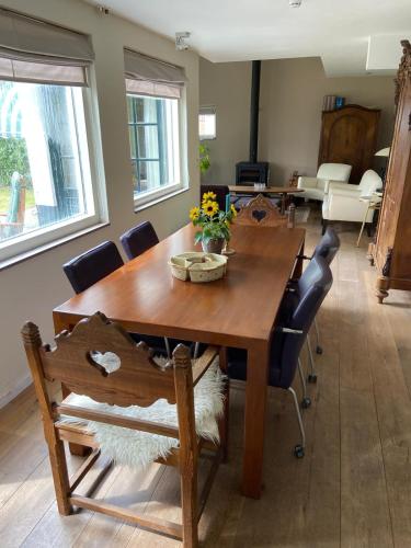 a dining room with a wooden table and chairs at House on estate near Amsterdam and Keukenhof in Lisserbroek