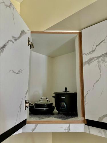 a reflection of a room with a stove in a mirror at Pool view Studio with WiFi & Netflix , Avida Riala in Cebu City