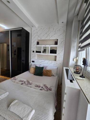 a small bedroom with a bed and a white wall at Arizona in Novi Sad