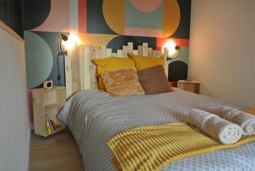 une chambre avec un grand lit avec des oreillers jaunes dans l'établissement Maison Sorbier, Appartement 1, à Nevers